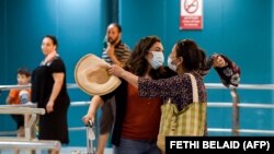 Une Tunisienne est accueillie à son arrivée à l'aéroport international de Tunis-Carthage, dans la capitale tunisienne, le 27 juin 2020. (Photo by FETHI BELAID / AFP)