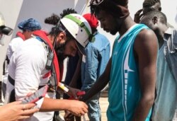 A member of the Medecins sans Frontieres (MSF) registers the details of a rescued migrant onboard the Ocean Viking rescue ship after 81 migrants were rescued from their dinghy in the Mediterranean Sea, Aug. 11, 2019.