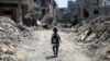 A Palestinian student walks between the rubble after attending a class in a tent set up on the rubble of the house of teacher Israa Abu Mustafa, as war disrupts school year, in Khan Younis, in the southern Gaza Strip, Sept. 4, 2024. 