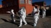 Dressed in full protective gear, doctors span out in a house-to-house new coronavirus testing campaign in the Villa Jaime Paz Zamora neighborhood of El Alto, Bolivia, July 4, 2020. 