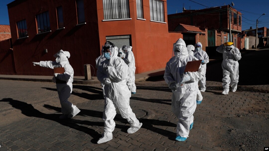 Dressed in full protective gear, doctors span out in a house-to-house new coronavirus testing campaign in the Villa Jaime Paz Zamora neighborhood of El Alto, Bolivia, July 4, 2020. 