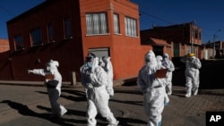 Dressed in full protective gear, doctors span out in a house-to-house new coronavirus testing campaign in the Villa Jaime Paz Zamora neighborhood of El Alto, Bolivia, July 4, 2020. 