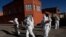 Dressed in full protective gear, doctors span out in a house-to-house new coronavirus testing campaign in the Villa Jaime Paz Zamora neighborhood of El Alto, Bolivia, July 4, 2020. 