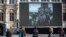 People watch former President Jacques Chirac on a giant screen set up at the Paris town hall, Sept. 27, 2019. Mourners signed memory books and flags were lowered in honor of the late president.