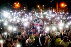 Aksi unjuk rasa "Black Live Matters" di Portland, Oregon, menghidupkan senter dengan mengangkat ponsel mereka, Senin, 20 Juli 2020. (AP Photo / Noah Berger)