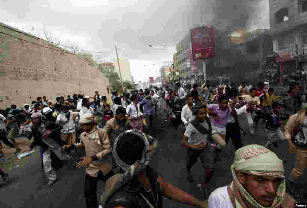 Anti-Houthi protesters run as pro-Houthi police troopers open fire in the air to disperse them in Yemen's southwestern city of Taiz, March 23, 2015.