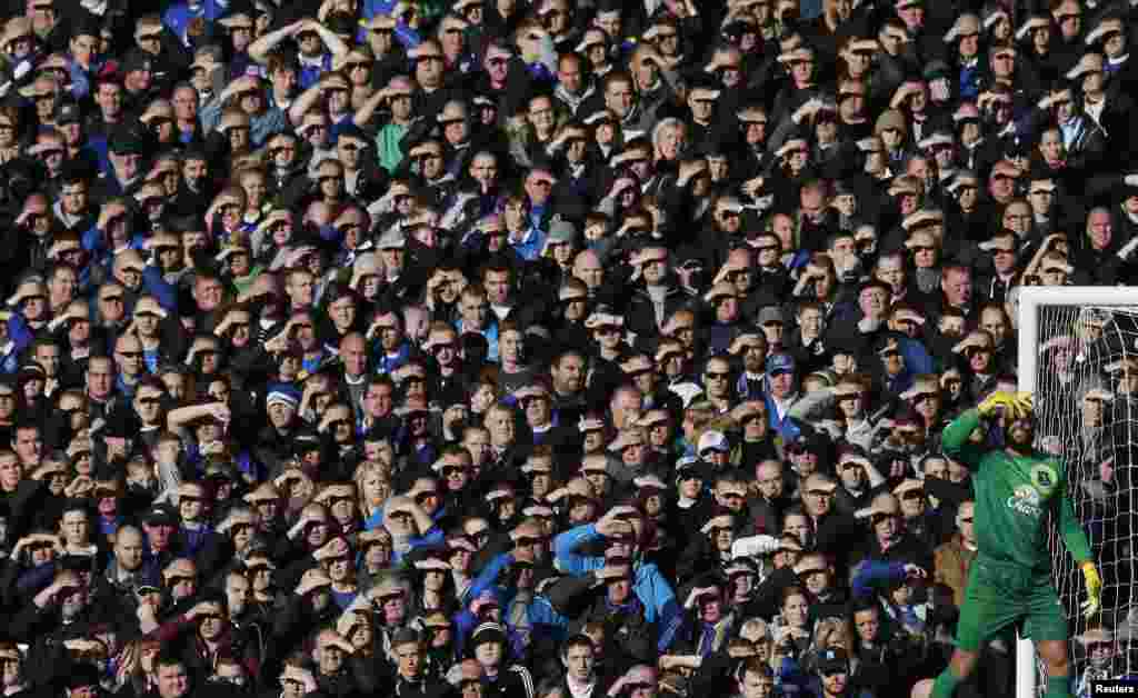 Everton goalkeeper Tim Howard shields his eyes from the sun during their English Premier League soccer match against Tottenham Hotspur at Goodison Park in Liverpool, northern England. 