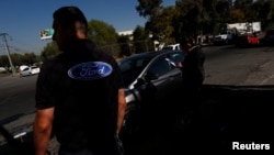 Logo Ford tampak di t-shirt yang dikenakan seorang pekerja (4/1). Cuautitlan Izcalli, Mexico. (foto: REUTERS/Carlos Jasso)