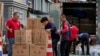 Workers load and pack gift boxes for the upcoming Mid-Autumn Festival, outside a supermarket in Beijing on Sept. 11, 2024.