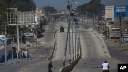 Un vehículo blindado circula por una calle principal que está vacía debido a los enfrentamientos entre la policía y las pandillas en el barrio de Delmas en Puerto Príncipe, Haití, el miércoles 12 de febrero de 2025.