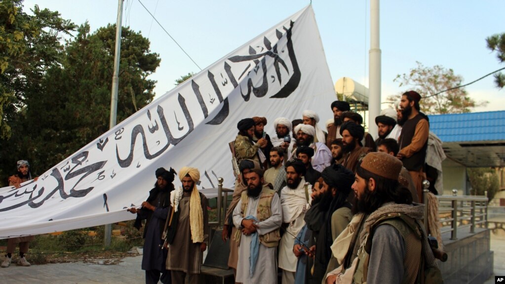 塔利班武装分子在加兹尼省省长官邸前留影。