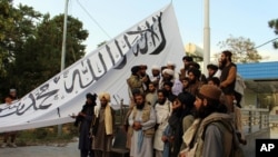 塔利班武装分子在加兹尼省省长官邸前留影。