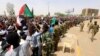 Sudanese military officers control demonstrators as they protest against the army's announcement that deposed president Omar al-Bashir would be replaced by a military-led transitional council, near Defense Ministry in Khartoum, Sudan, April 12, 2019.