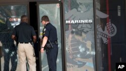 Agentes policiales entran al Centro de Carrera de las Fuerzas Armadas a través de la puerta impactada por las balas, en Chattanooga, Tennessee, este jueves 16 de julio de 2015.
