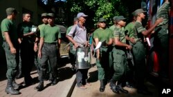 A Sri Lankan municipal worker, center, along with army soldiers leave for Dengue fever eradication work in Colombo, Sri Lanka, July 4, 2017. 