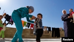 Seorang pengunsi perempuan membantu saudaranya yang dicurigai mengidap polio, untuk berjalan di sebuah kompleks masjid wilayah Shebaa, Lebanon Selatan (28/10).