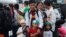 A father and his children who survived the massive Typhoon Haiyan, wait for an evacuation flight on the tarmac of the airport in Tacloban, Philippines, Nov. 21, 2013.