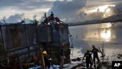 A rescue team wades into flood waters to retrieve a body in Tacloban, central Phillipines, Nov. 13, 2013. 