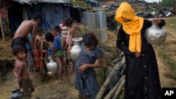 FILE - Rohingya Muslims collect water from a tube well at a refugee camp at Cox's Bazar Ukhia area, Bangladesh, Sept. 9, 2017.