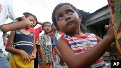 Two-year-old Arfaisal Marsaleh, a stateless child, holds on to his mother in a slum village in Kinarut, in Malaysia's Sabah state on Borneo island (file photo).