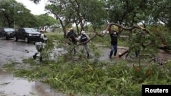 Miembros de la Guardia Nacional quitan ramas de árboles de una calle después de que el huracán Grace tocó tierra en la península de Yucatán, en Mérida, México, el 19 de agosto de 2021.