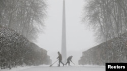 Workers remove snow during a heavy snowfall in Kyiv, Ukraine, Dec. 18, 2017. 