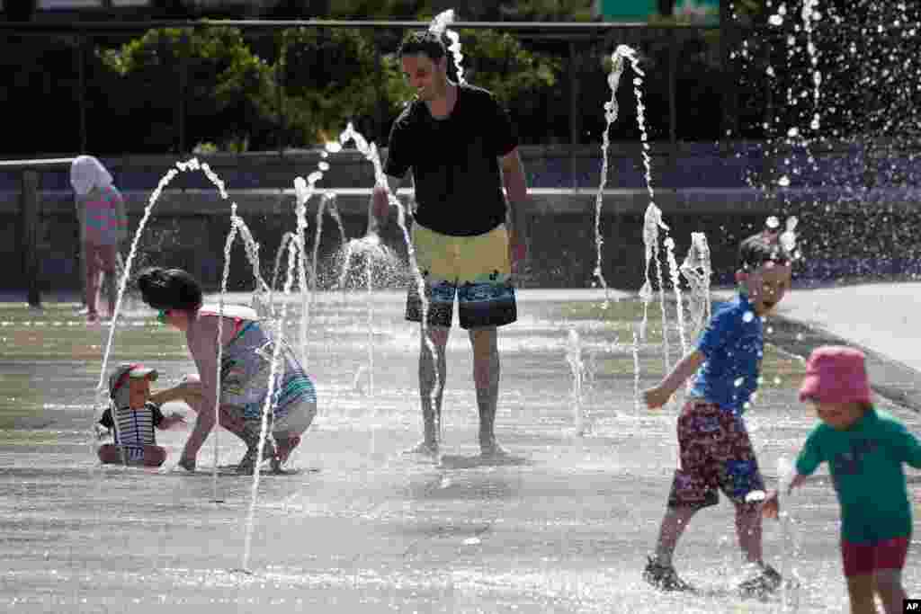 هوای گرم در شهر بوستون، برخی خانواده‌ها و بچه‌ها را گرد فواره پارک جمع کرده است. 