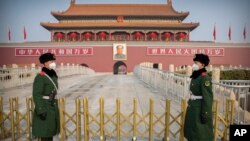 Paramilitary police wear face masks as they stand guard at Tiananmen Gate adjacent to Tiananmen Square in Beijing, Monday, Jan. 27, 2020. China on Monday expanded efforts to contain a viral disease by postponing the end of this week's Lunar New Year. (AP Photo/Mark Schiefelbein)