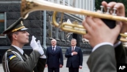 FILE - Ukrainian President Petro Poroshenko, background right, and Belarusian President Alexander Lukashenko, background left, listen to a national anthem during a welcome ceremony in Kiev, Ukraine, Friday, July 21, 2017. (AP Photo/Mykhailo Markiv, Presidential Press Service Pool Photo via AP)