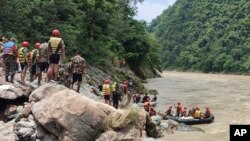 Army personnel in Nepal carry out a search operation after a landslide swept two buses off the highway and into a swollen river near Simaltal, about 120 kilometers (75 miles) west of the capital, Kathmandu, July 13, 2024.