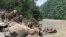 Army personnel in Nepal carry out a search operation after a landslide swept two buses off the highway and into a swollen river near Simaltal, about 120 kilometers (75 miles) west of the capital, Kathmandu, July 13, 2024.