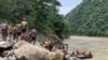 Nepal army personnel cary out a search operation looking for the survivors after two buses were swept by a landslide off the highway and into a swollen river near Simaltal, about 120 kilometers (75 miles) west of the capital Kathmandu, Nepal, July 13, 2024.