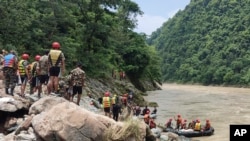 Nepal army personnel cary out a search operation looking for the survivors after two buses were swept by a landslide off the highway and into a swollen river near Simaltal, about 120 kilometers (75 miles) west of the capital Kathmandu, Nepal, July 13, 2024.