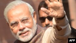 India's new Prime Minister Narendra Modi (C) gestures during his arrival at the Prime Minister's Office at South Block in New Delhi on May 27, 2014.