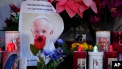 Candles are seen near pictures of Pope Francis outside the Agostino Gemelli Polyclinic in Rome, Feb. 23, 2025, where the pontiff has been hospitalized since Feb. 14.