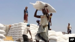 FILE - Men deliver U.N. World Food Program (WFP) aid in Aslam, Hajjah, Yemen, Sept. 21, 2018.