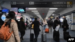 En la foto de archivo se ven a pasajeros caminando por una terminal abarrotada en el aeropuerto internacional de Dulles en Dulles, Virginia.