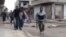 Image made from amateur video purports to show a Syrian rebel helping an injured man in Rastan, Homs, Syria.