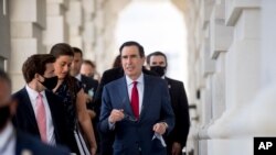 Treasury Secretary Steven Mnuchin, center, leaves following a meeting with House Speaker Nancy Pelosi of Calif. and Senate Minority Leader Sen. Chuck Schumer of N.Y. as they continue to negotiate a relief package on Capitol Hill, Aug. 7, 2020.