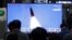 Orang-orang menonton TV yang menampilkan gambar peluncuran rudal Korea Utara dalam program berita di Stasiun Kereta Api Suseo di Seoul, Korea Selatan, Kamis. 25 Maret 2021. (Foto: AP)