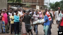 Men carry a body in the Nyakabiga neighborhood of Bujumbura, Burundi, where a number of people were found shot dead a day after the government said an unidentified group had carried out attacks on three military installations, Dec. 12, 2015.