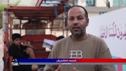 پیاوێک لە بەسرە کتێب بە خۆڕایی بەسەر خوێندکاراندا دابەش دەکات
