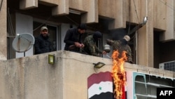 Anti government forces set the Syrian flag on fire in the city of Salamiyah in the central Hama governorate, Dec. 7, 2024.