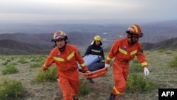 This photo taken on May 22, 2021 shows rescuers carrying equipment as they search for runners who were competing in a 100-kilometre cross-country mountain race when extreme weather hit the area, leaving at least 20 dead, near the city of Baiyin in…