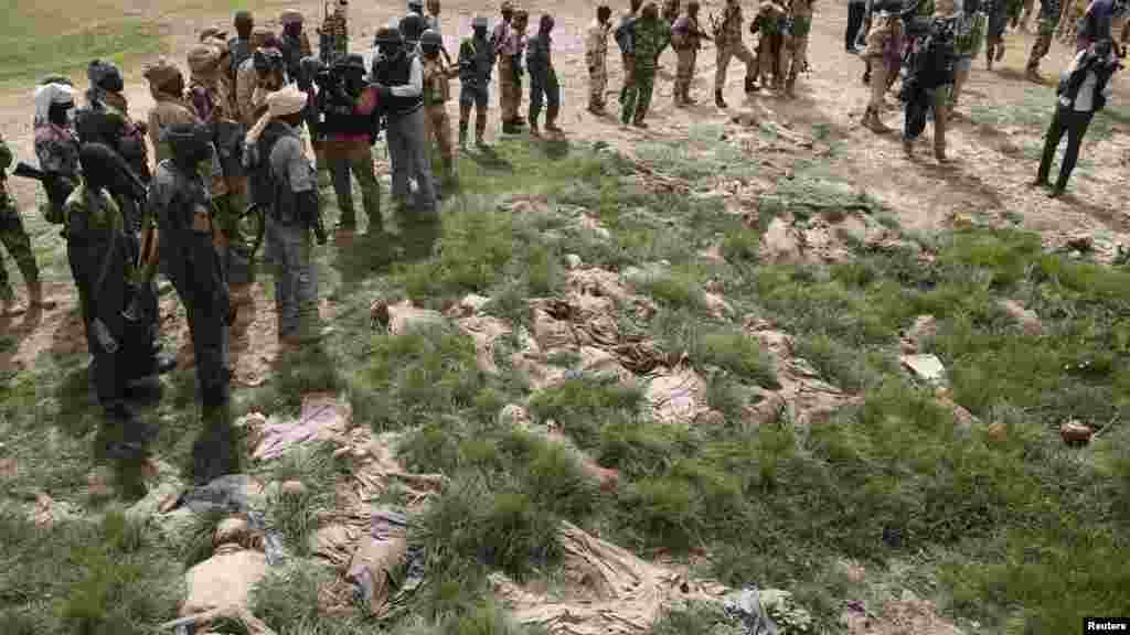 Des soldats et des journalistes tchadiens contemplent des cadavres en décomposition sous un pont à Damasak, ville récemment reprise de Bokok Haram, au Nigeria, le 20 Mars 2015.