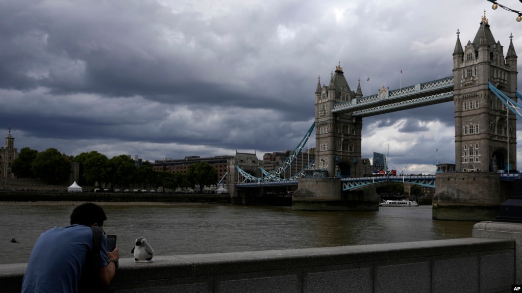 2022年7月25日，一名男子在伦敦塔桥前拍照.(photo:VOA)