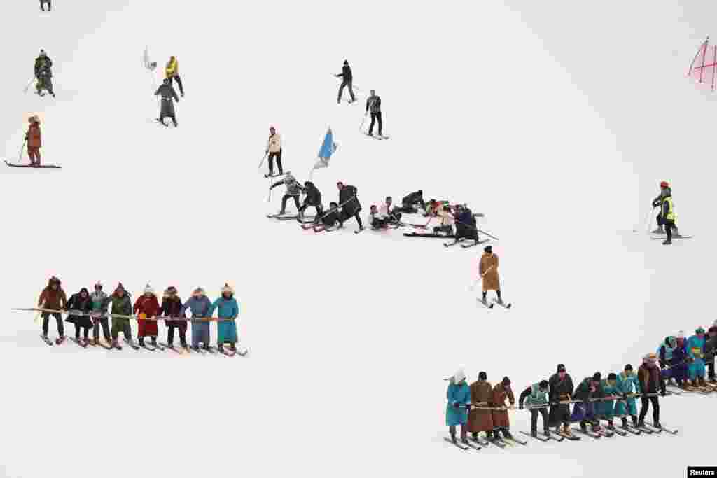 People perform on traditional horsehide skis during an event to celebrate the origins of skiing at the Jiangjunshan, or General&#39;s Mountain, ski resort in Altay, Xinjiang, Uighur Autonomous Region, China, Nov. 27, 2019.