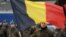 A Belgian soldier holds his national flag during a ceremony to welcome the German battalion being deployed to Lithuania as part of NATO deterrence measures against Russia in Rukla, Lithuania, Feb. 7, 2017.