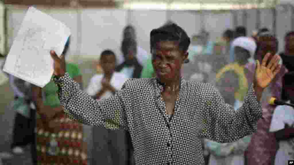 Cette femme, déclarée guérie d&rsquo;Ebola, rend grâce à Dieu après avoir été libérée de la clinique de traitement d&rsquo;Ebola à Monrovia, Liberia. Elle devra cependant être acceptée à nouveau dans sa communauté. Le 30 septembre 2014. (AP Photo/Jerome Delay) 