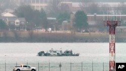 Search efforts are seen around a wreckage site of a deadly midair collision between an American Airlines jet and an Army helicopter, in the Potomac River near Ronald Reagan Washington National Airport, Jan. 31, 2025, in Arlington, Va